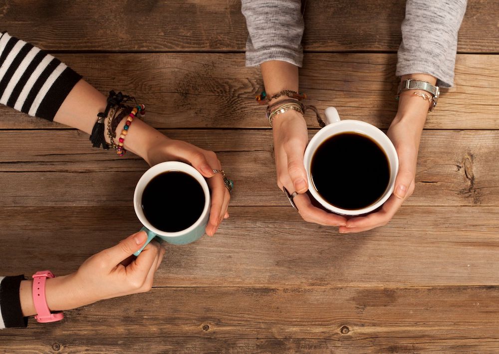 dua cangkir kopi hitam di genggaman