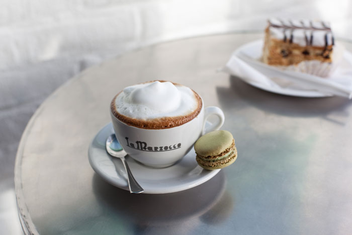 secangkir cappuccino klasik dengan biskuit