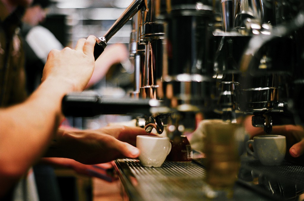 Secangkir espresso sedang dalam pembuatan dengan menggunakan mesin espresso