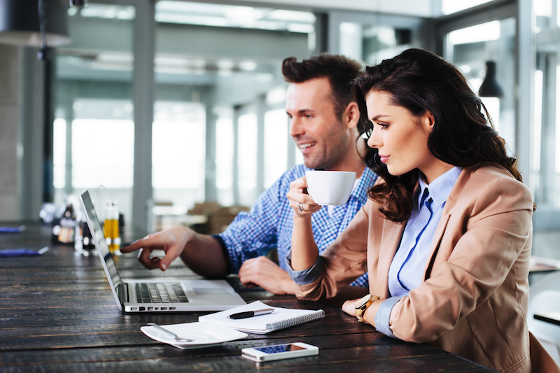 melihat layar laptop sambil minum kopi