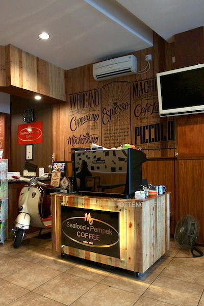 Di sebelah mesin espresso bertengger vespa klasik nan asik.