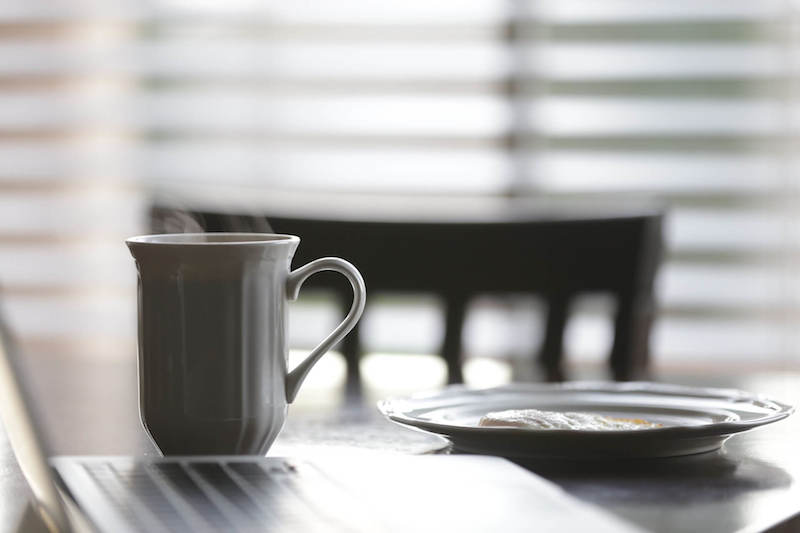 secangkir kopi panas di atas meja dengan penganan