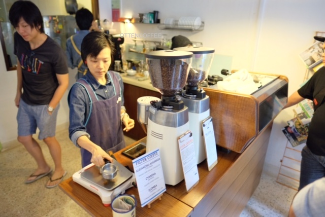 Barista beraksi di balk coffee bar.