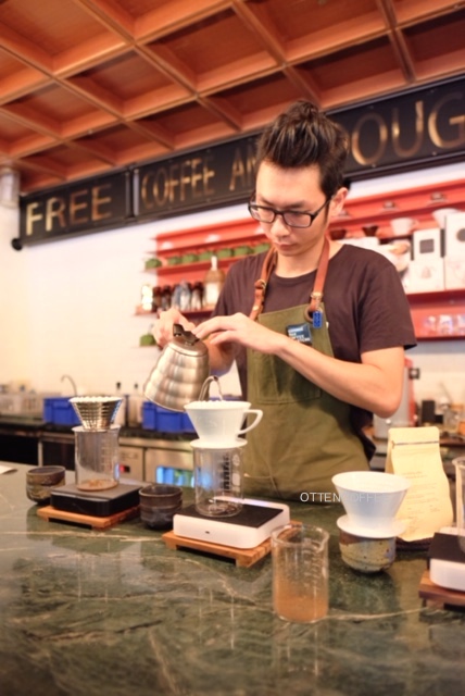 Sang barista sedang menyeduh kopi kami.