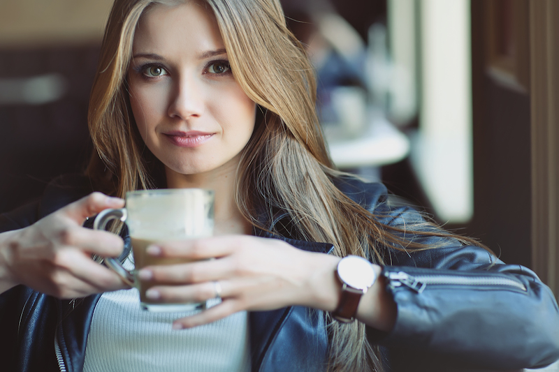 perempuan memegang gelas kopi susu