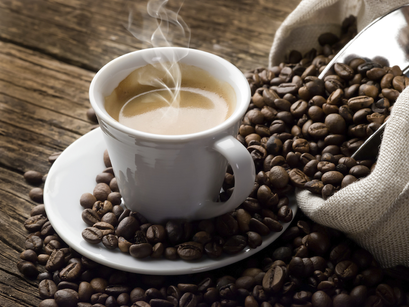 secangkir kopi dan biji kopi berserakan