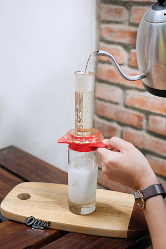 menuangkan air panas ke alat espresso maker