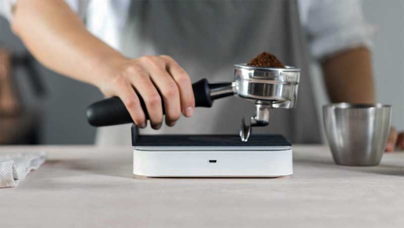 barista sedang menimbang portafilter pada timbangan kopi