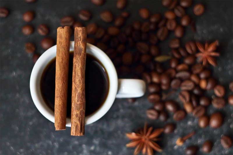 secangkir kopi hitam dengan kayu manis