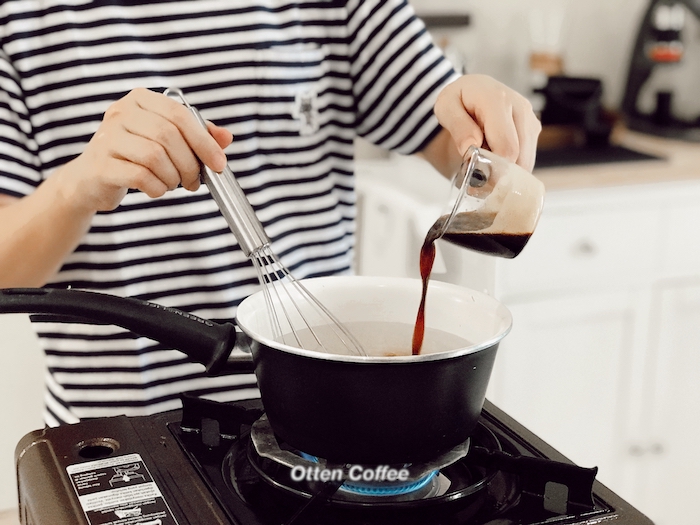 menuangkan kopi ke didihan air di panci
