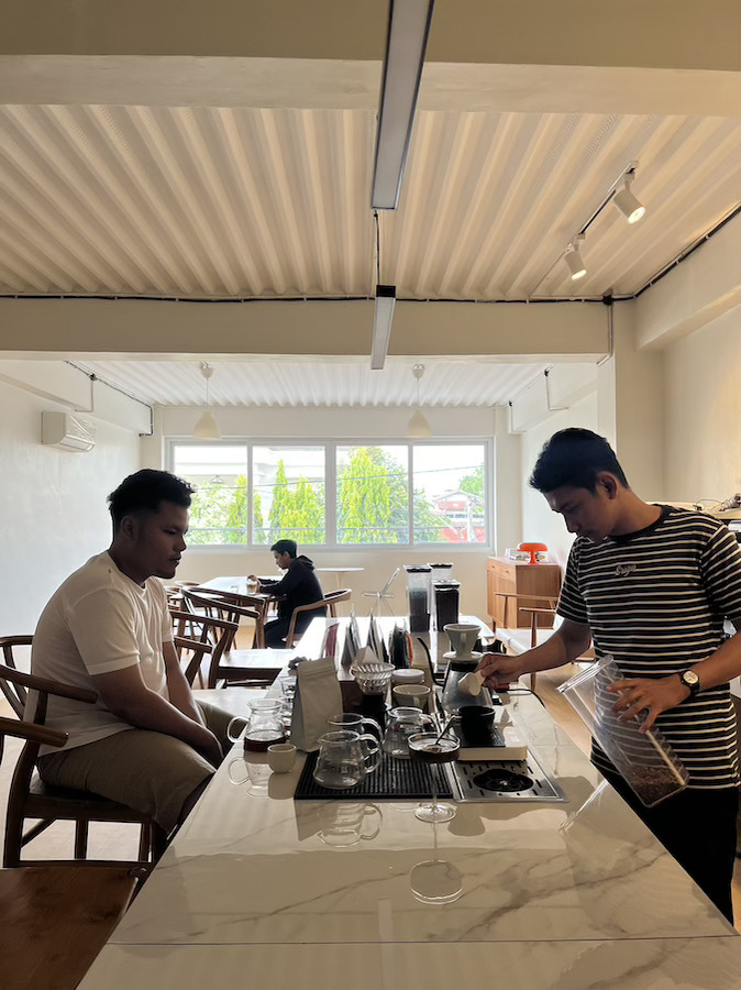 melayani pengunjung di kedai kopi