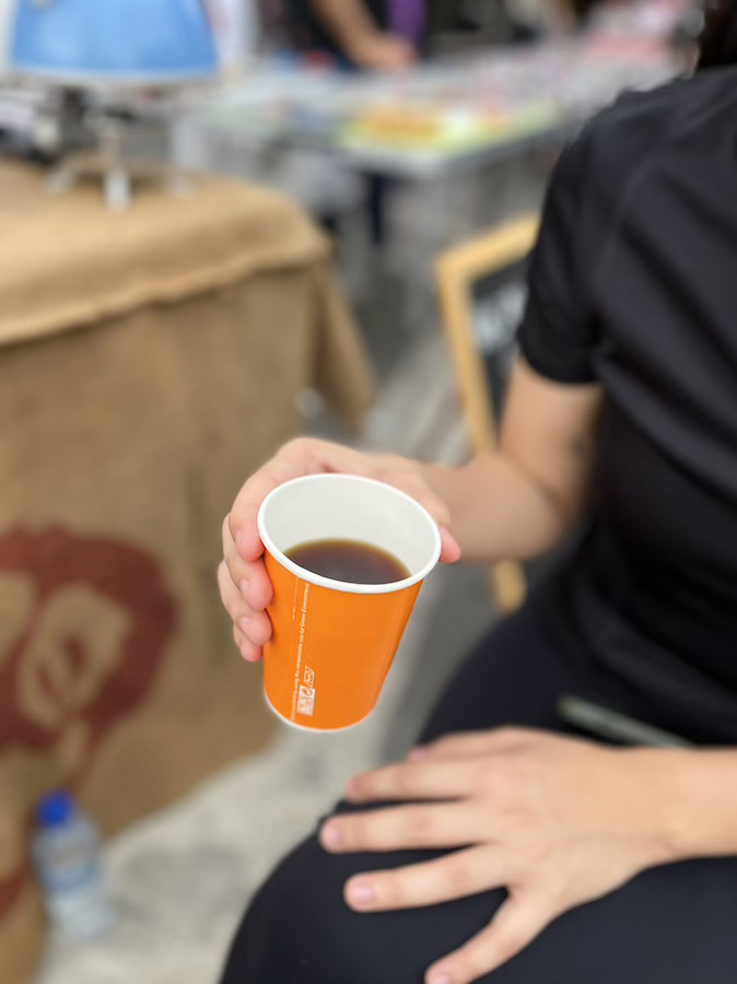 seseorang pegang kopi di cangkir kertas