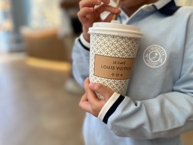 anak anak memegang cup Louis Vuitton